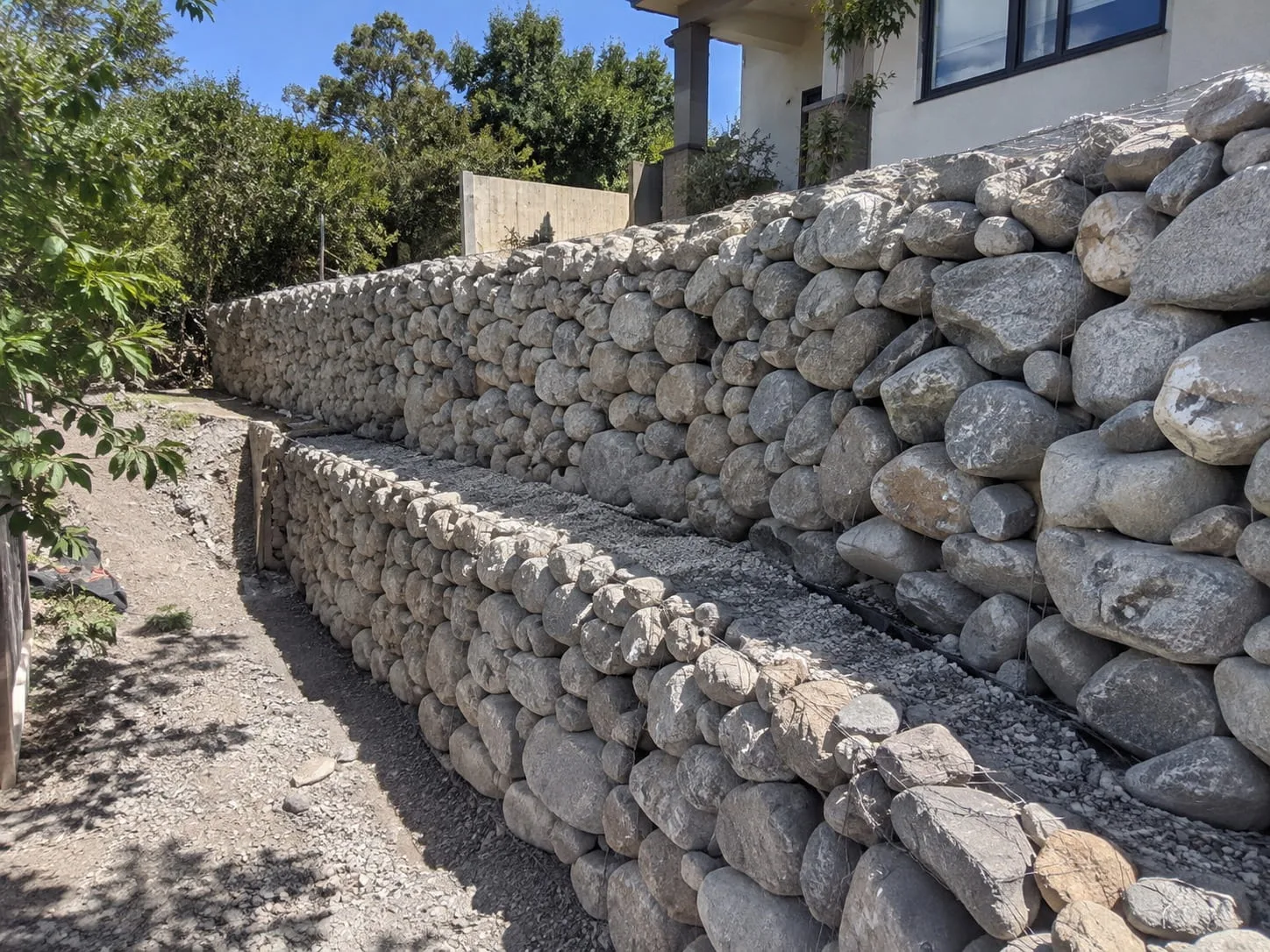 Boulder retaining wall stabilising a slope in Christchurch